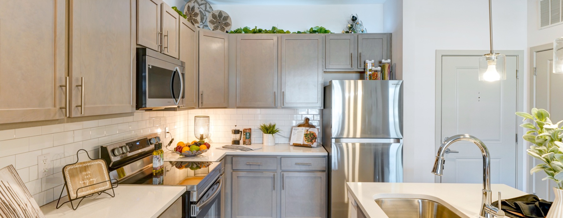 Apartment kitchen with gray cabinets and an island with a sink