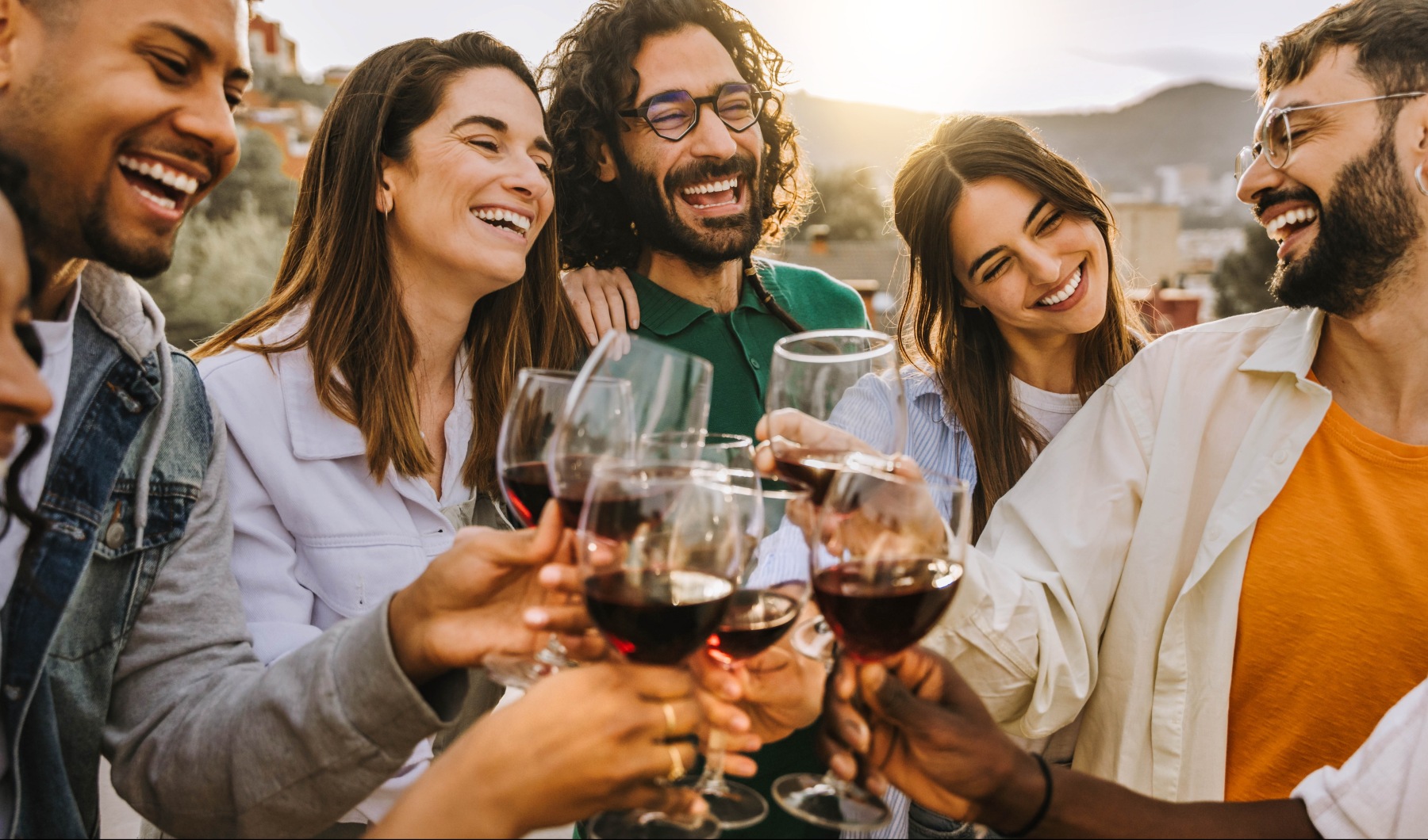 Group of friends holding glasses of red wine